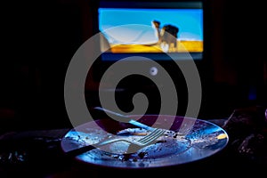 Empty plate in front of tv - lonely night
