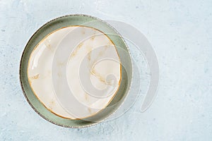 An empty plate with a gold rim, overhead flat lay shot on a slate background