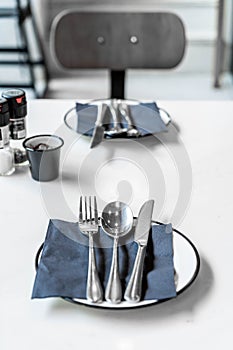 empty plate with knife spoon and fork on table