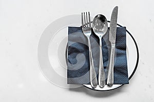 empty plate with knife spoon and fork on table
