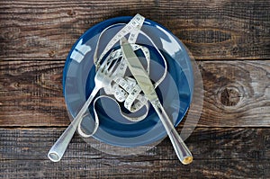 Empty plate with measuring tape, knife and fork. Diet food