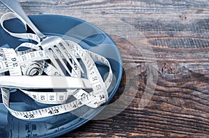 Empty plate with measuring tape, knife and fork. Diet food