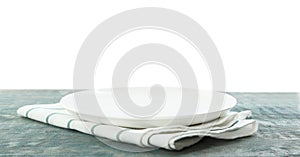 Empty plate and napkin on blue table against white background