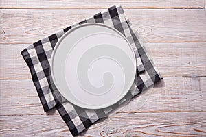 Empty plate and napkin on white wooden table. Empty tray mock up for design. Top view.