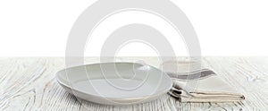 Empty plate and napkin on wooden table