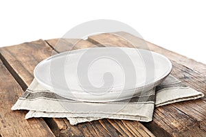 Empty plate and napkin on wooden table against background