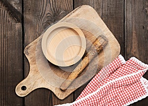Empty plate and old brown rectangular wooden kitchen cutting board on the table