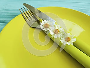 Empty plate rustic on a blue wooden background menu daisy flower fork, knife