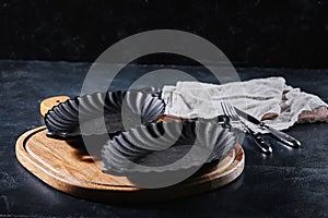 Empty plate with silverware on wooden table over bokeh background