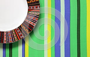 Empty plate on striped tablecloth