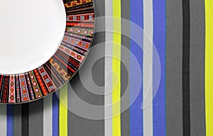 Empty plate on striped tablecloth