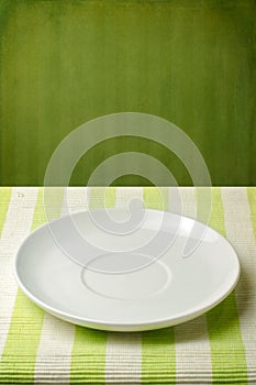 Empty plate on striped tablecloth