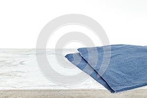 Empty plate on tablecloth on wooden table over grunge background