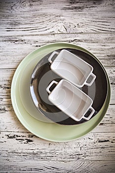 Empty plates and dishes for baking on a white wooden table closeup and copy space