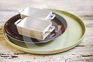 Empty plates and dishes for baking on a white wooden table closeup and copy space