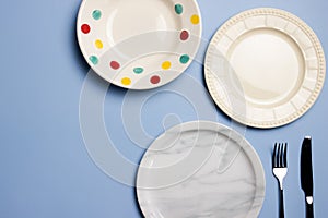 Empty plates with dots, marble and white over the blue background.