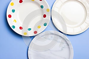 Empty plates with dots, marble and white over the blue background.