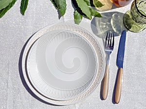 Table setting for dinner. White plates, napkins and flower decorations close-up. Festive tableEmpty plates on festive served dinne photo
