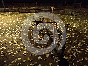 An empty playground with metal teeter at night and creepy atmosphere