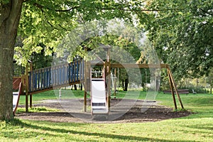 Empty playground with swing and slide on grass fiel