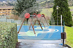 Empty playground with swings and rubber flooring in a hilly area