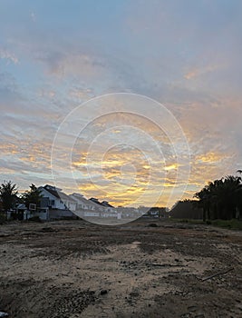 an empty plot of land scene besides a residential row of houses.