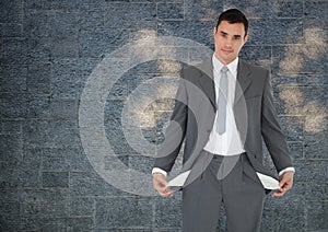 empty pockets businessman with rock wall background