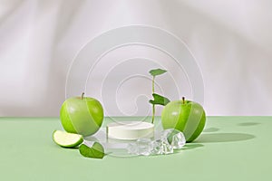 Empty podium in white color arranged with ices and fresh green apples.