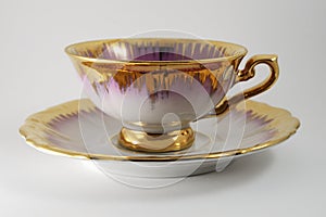 Empty porcelain tea cup with gilding on a white backdrop