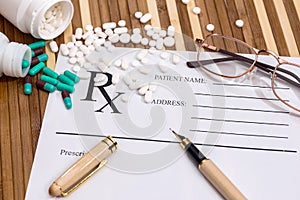 Empty prescription with dispersed pills, glasses and pen