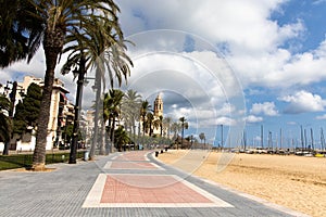 Empty promenade Passeig de la Ribera with the views of church Sant Bartomeu y Santa Tecla, Sitges, Catalonia, Spain