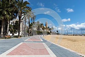 Empty promenade Passeig de la Ribera with the views of church Sant Bartomeu y Santa Tecla, Sitges, Catalonia, Spain