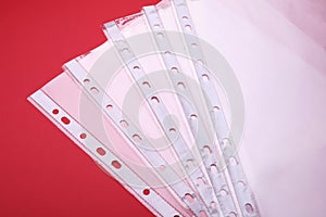 Empty punched pockets on red background, above view