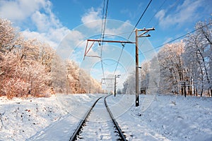 Empty railroad with electric mainline in winter forest