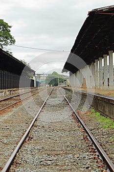Empty railroad track going through old city station. Perspective view