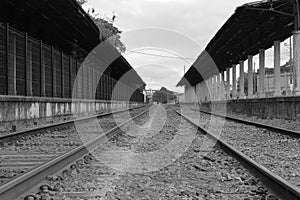 Empty railroad track going through old city station. Perspective view