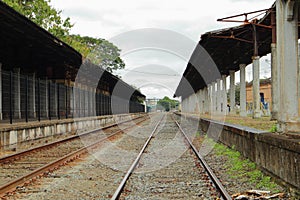 Empty railroad track going through old city station. Perspective view