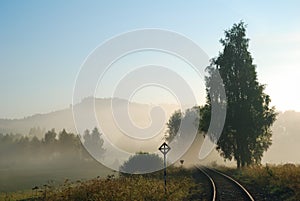 Empty railway track in a foggy countryside