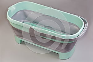 Empty rectangular mop folding bucket with handle on gray background