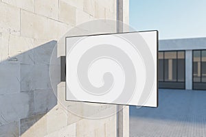 Empty rectangular white stopper on concrete building. Bright city with sunlight background. Ad, pub, cafe, or restaurant banner.