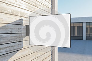 Empty rectangular white stopper on wooden building. Bright city with sunlight background. Ad, pub, cafe, or restaurant banner.