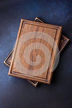 Empty rectangular wooden cutting board on dark concrete background