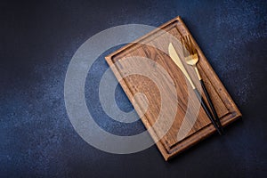 Empty rectangular wooden cutting board on dark concrete background