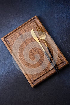 Empty rectangular wooden cutting board on dark concrete background