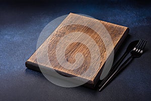Empty rectangular wooden cutting board on dark concrete background