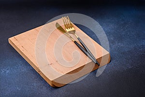 Empty rectangular wooden cutting board on dark concrete background