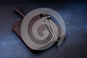 Empty rectangular wooden cutting board on dark concrete background