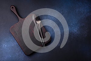 Empty rectangular wooden cutting board on dark concrete background