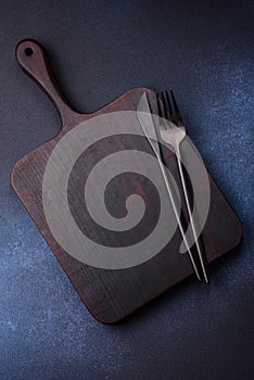 Empty rectangular wooden cutting board on dark concrete background