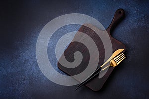 Empty rectangular wooden cutting board on dark concrete background